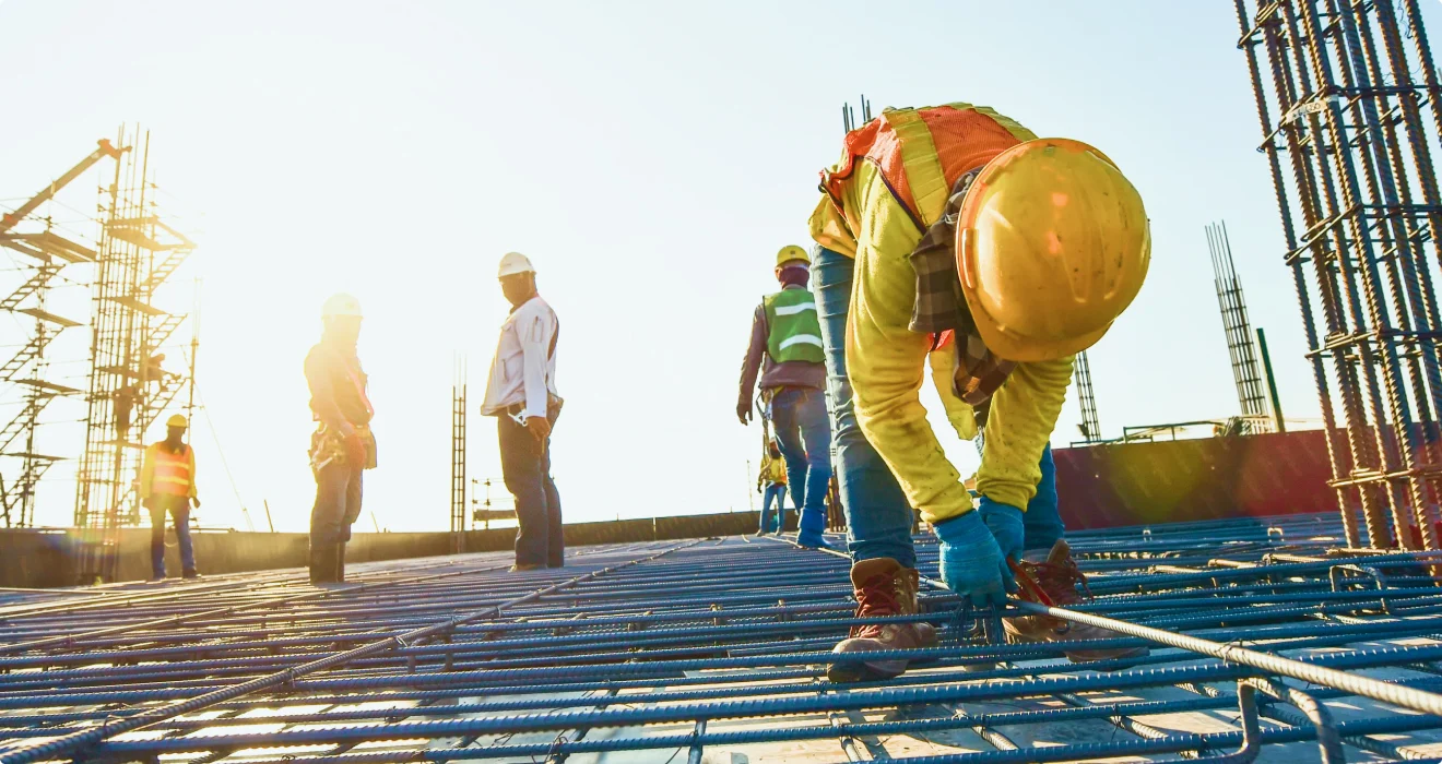Steel construction workers on building site with reinforcement bars